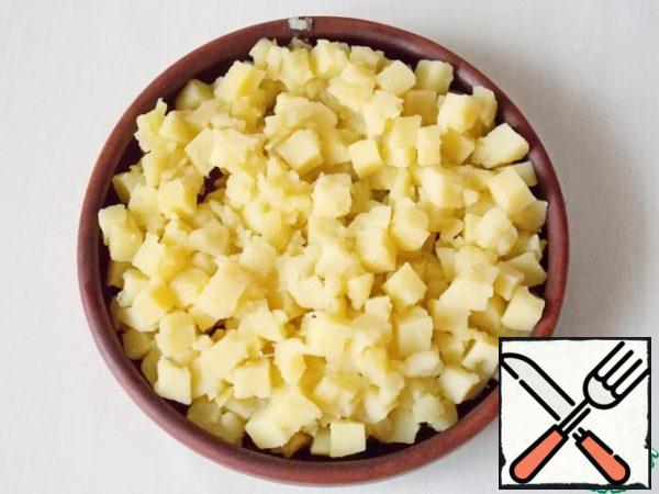 We cook our potatoes over medium heat until tender, but they should not be overcooked. I got a little distracted and was late with this, watch out for potatoes. We throw it on a sieve to stack the broth. Grease the baking dish with oil and put the potatoes in it.