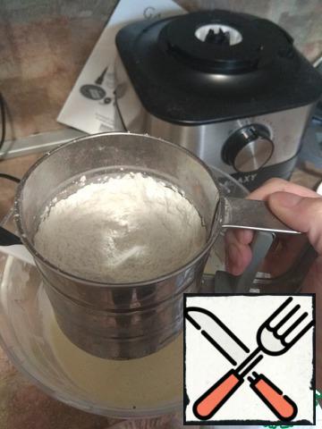 Gradually pour the dry mixture into the egg-sour cream, mix everything with a silicone spatula.