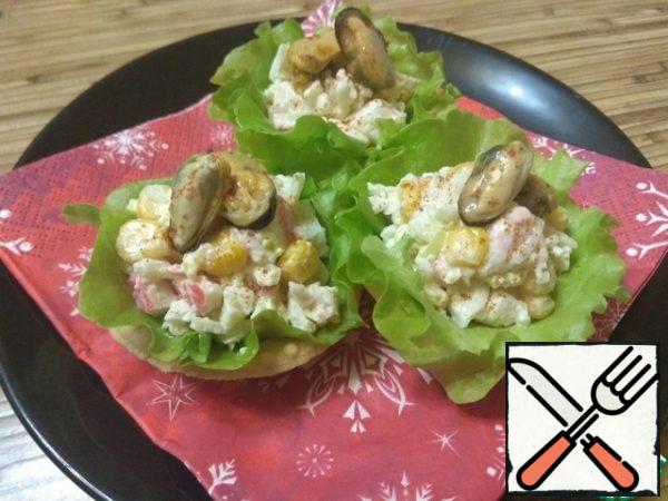 Spread the finished salad on tartlets, put mussels on top. Garnish with a pinch of sweet paprika and lettuce leaves.