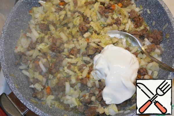 When the meat is gray and the vegetables are half-cooked, add the chopped Peking cabbage as small as possible. Lightly fry and add a little water. Simmer for 2 minutes. Add sour cream and