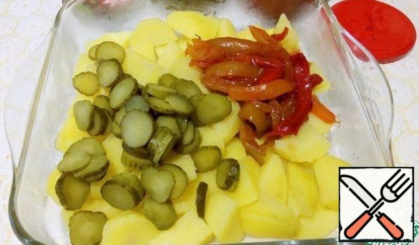 Peel the potatoes, cut into large cubes, pour boiling water, put on fire and let boil, add salt, cook for 10 minutes after boiling and throw in a colander. Grease the mold with butter, lay out the potatoes. Very tasty pickled delicatessen cucumbers cut into thin rings. We spread all this beauty with cucumbers and lecho on potatoes.