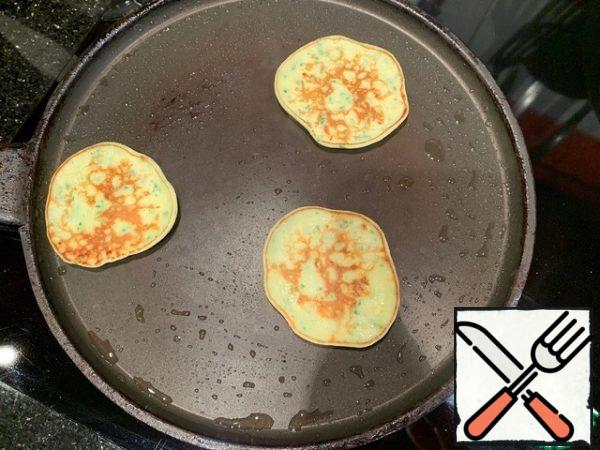 Fry small pancakes in a hot pan, greased with vegetable oil.