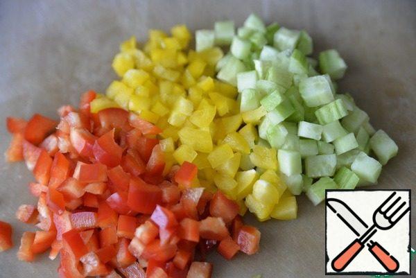 Take cucumber and bell pepper red and yellow. Vegetables are washed , cleaned, cut into cubes.