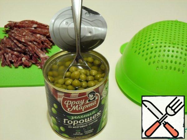 Toss the green peas in a colander and shake the liquid well.