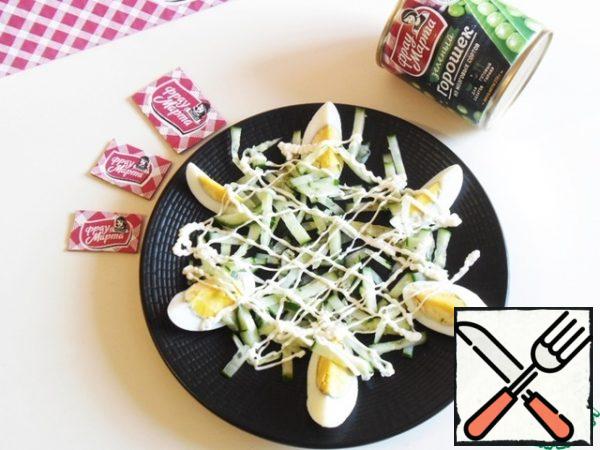 Description on the example of one serving, the ingredients are given for three servings.
Cool the boiled eggs under cold water, peel and cut into 6 slices each.
Put one sliced egg on each plate.
Sprinkle a third of the cucumber straws on top, squeeze out the mayonnaise with a grid over the entire surface, and add a little salt.