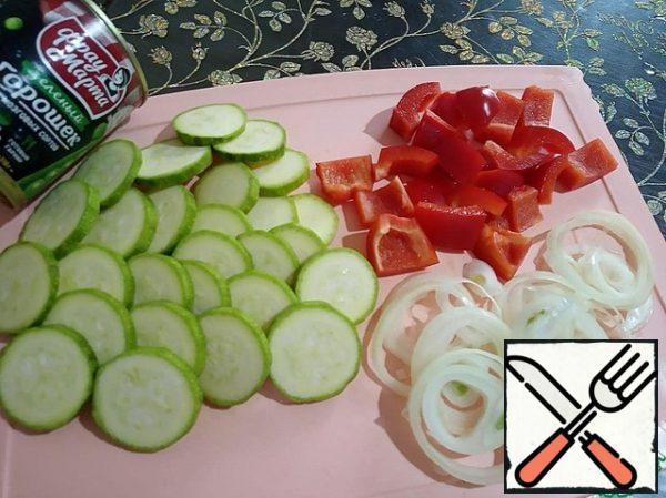 Peel the onion and cut it into rings. Zucchini cut into thin slices, wash and dry. Peppers are cleaned from seeds and cut into large pieces.