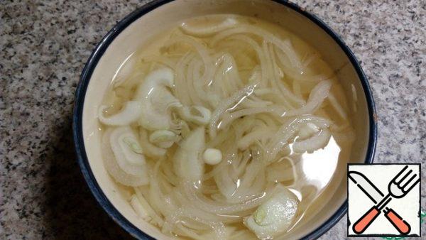 Cut the onion into half rings and marinate in a mixture of water and vinegar for 5-10 minutes . Then squeeze.