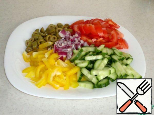 Cut vegetables.
Pepper and cucumbers straws, olives circles. onion in small cubes.
Tomatoes-slices.