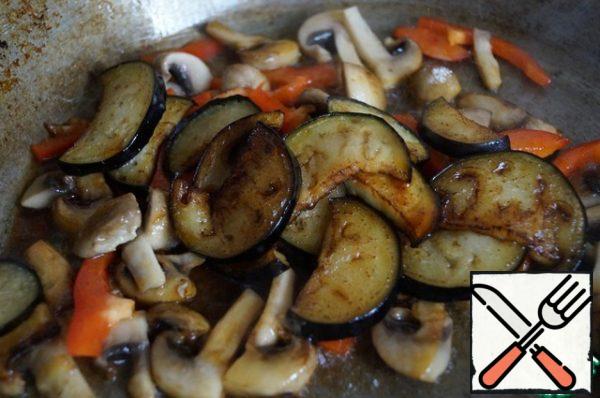 Add the ready-made eggplants to the vegetables, season everything with a mixture of soy sauce and vinegar and warm everything together in a pan for a minute.