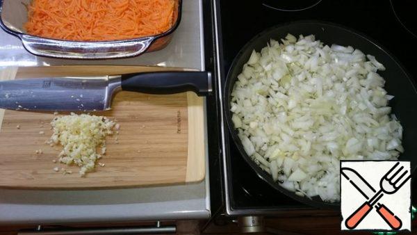 By the end of marinating carrots, we need to prepare oil with onion flavor.To do this, fry the chopped onions in vegetable oil until light brown (about 15-20 minutes). At the same time, finely chop the garlic (I do not forbid press).