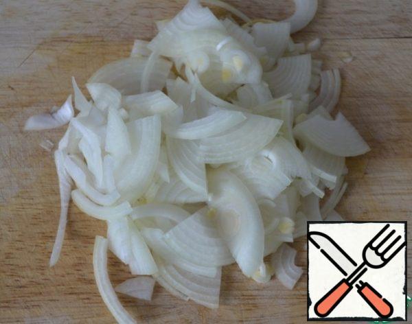 Peel and cut the onion into half rings.