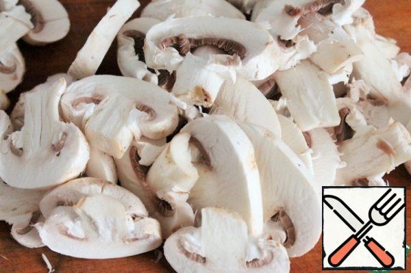 Wipe the mushrooms with a damp cloth, do not wash them. We cut off heavy dirt. If the small mushrooms are left whole, if large and medium, then cut into plates, not very thin.