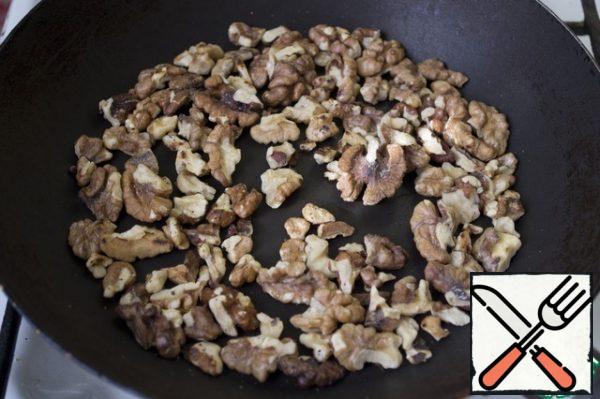 Fry the walnuts, stirring constantly, in a dry frying pan.