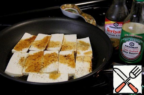 Pour the sesame oil into the pan and put the tofu pieces, side down with the spices. Top with the same spices and pour teriyaki sauce and soy sauce.
there shouldn't be too much of it.