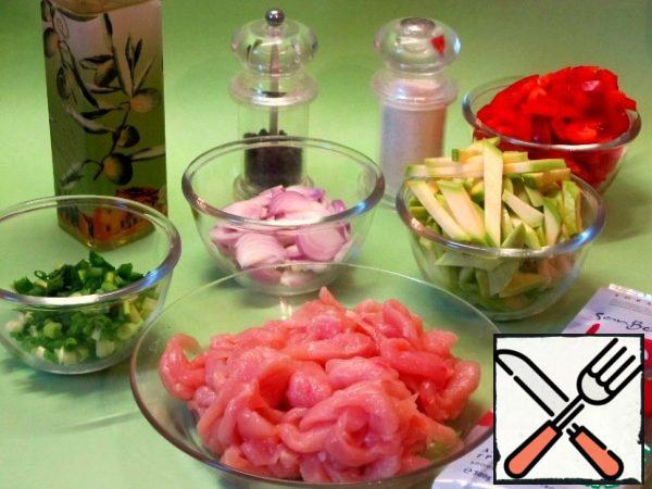 Wash the chicken fillet, dry it with a paper towel, and cut it into thin strips.
Sweet red pepper, it is more flavorful, and red onion cut into strips.
Zucchini cut into cubes,
4 stalks of green onions cut into small pieces.