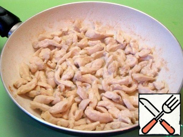 Heat the vegetable oil in a frying pan and fry the chicken strips.