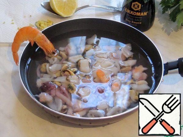 Sea cocktail (peeled shrimp, squid strips, squid tentacles, mussel meat, pieces of octopus tentacles) defrost, then boil with a slice of lemon for 5-7 minutes.