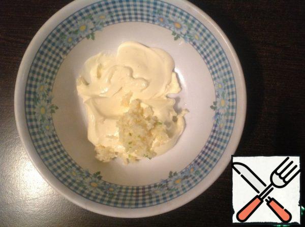 Add mayonnaise to the Cup, squeeze 2-3 cloves of garlic through the press (focus on your taste), mix well.