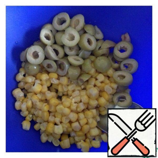 Drain the excess liquid from the corn. Cut the olives into slices.