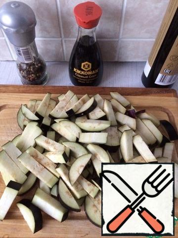 Wash the eggplants and cut them into thick strips.