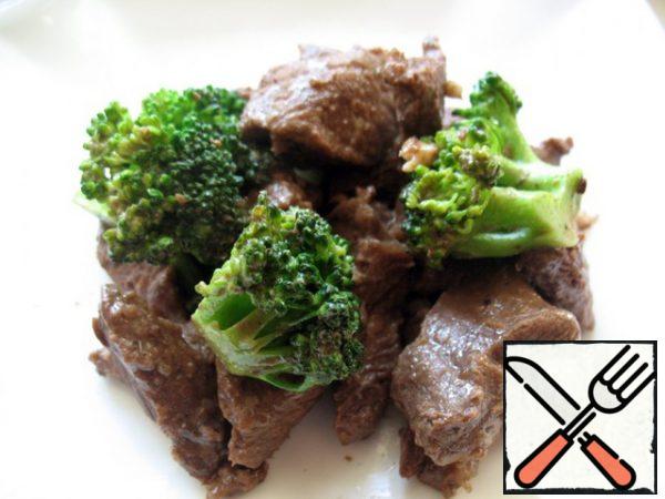 Heat the oil in a wok. Put the grated ginger and finely chopped garlic and simmer for 30 seconds. Add the beef and simmer for about 5-7 minutes, stirring constantly.
Add the broccoli stalks and simmer until tender, but the broccoli should remain bright green and slightly crispy (about 5 minutes). At the end, pour in sesame oil.

Serve best with fried rice.