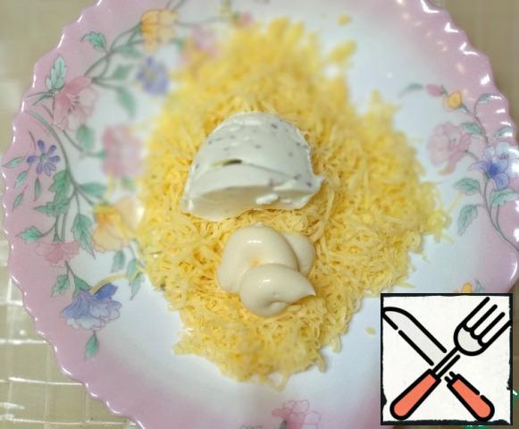 Grate the cheese on a fine grater, add mayonnaise and cottage cheese, mix well.