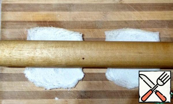 Roll out the bread slices with a rolling pin.