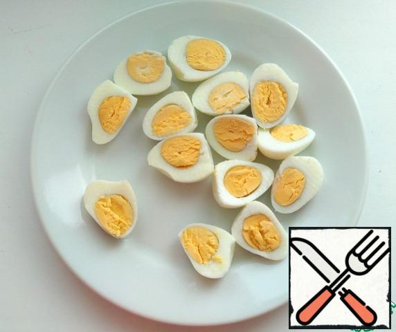 Boil the quail eggs, peel and cut into halves.