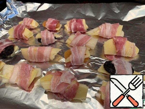 Place all such rolls on a baking sheet and bake in a preheated 180-degree oven for 10-15 minutes, until the bacon is browned.