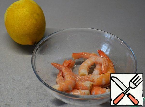 Peel the shrimp from the shell, leaving the tail, add salt, sprinkle with lemon juice.