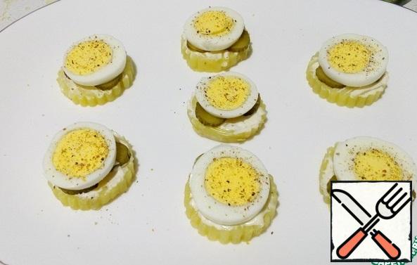 Cut the eggs into rings and spread over the cucumbers, sprinkle with freshly ground pepper on top.