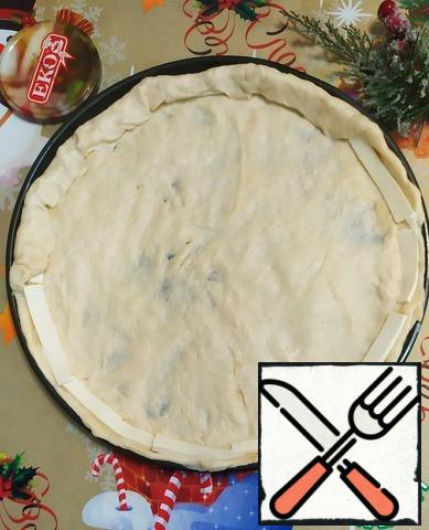 The finished dough is rolled into a round billet of the desired thickness. Place on a baking sheet. Next, make small sides, spread the curd cheese around the edges and close the dough.