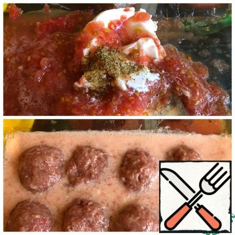 In a baking dish, put sour cream, a pinch of salt and tomato, grated on a large grater. Pour in the water and stir the sauce. Form the meatballs and put them in the sauce. Put in the oven for 20-30 minutes at 190*C.