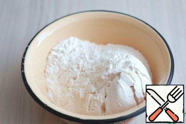 In a separate bowl, mix all the dry ingredients for the dough: flour (400 g), salt (1 chip), vanilla sugar (1 pack), baking powder (1 tsp). The mixture is stirred.
Combine the butter and egg mixture and the dry ingredients. Knead a soft plastic dough.