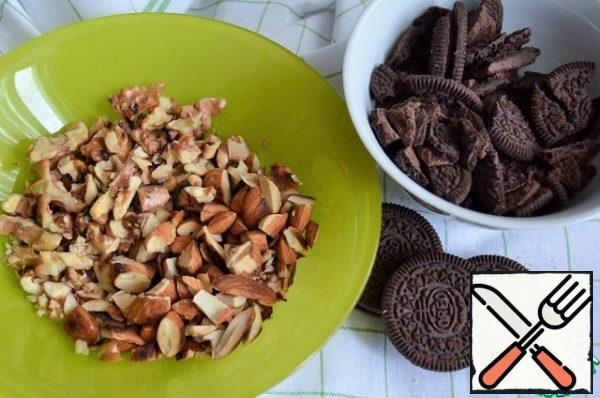 Before assembling the cake, prepare everything for the filling.
Peel the nuts, fry them in a dry frying pan and, if possible, remove the husks.
Chop the cookies and nuts. Leave some for decoration.