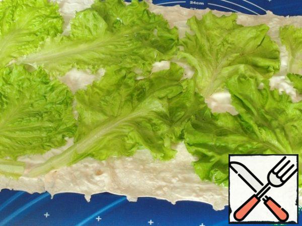 Wash and dry the lettuce leaves and put them on top. Then cover with a second sheet of pita bread.