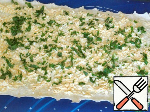 Grate hard cheese and boiled eggs, mix. The second lavash is greased with the remaining cheese, sprinkle with a mixture of cheese and eggs, and chopped parsley before reaching the edge of 15 cm.