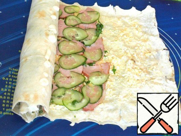 Gently twist the pita bread into a roll, lightly smearing it with mayonnaise when twisting to secure it. The free edge should also be lubricated with mayonnaise and fix the pita bread