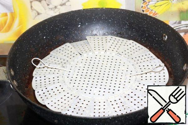 Pour 5 cm of water into the wok, place a steaming stand there and put it on the stove to boil.