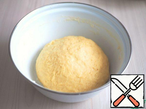 Knead dough. The container with the dough is covered with food wrap and put in a warm place to rise. After the first rise, knead the dough and put it to rise again. Then put the dough in the refrigerator for about 30-40 minutes. You can stay for an hour.