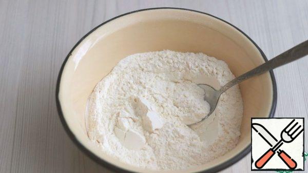 In a separate bowl, combine all the dry ingredients: flour (250 gr.), baking powder (1 package). Combine the egg-butter mixture and a mixture of dry ingredients. Knead a soft dough.
