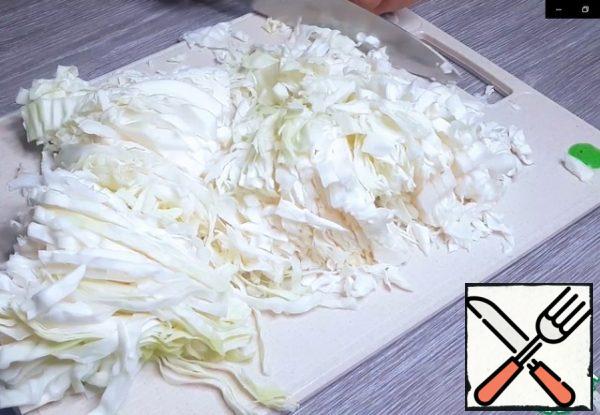 Onion cut into slices, carrots grate on a large grater. Chop the cabbage.