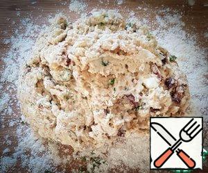 The surface is strongly sprinkled with flour, transfer the dough. Collect the dough in a ball - do not knead! flatten the dough with your palms into a round cake to a thickness of 2.5 - 3 cm.