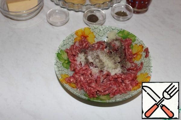 Add the grated onion to the minced meat. Add salt and pepper and mix well.