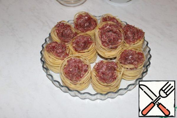 Fill the nests with minced meat, leaving a small depression in the middle.