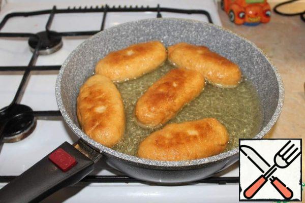 Fry the pies in a large amount of sunflower oil until golden brown.