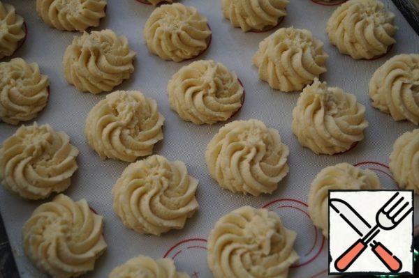 Put the dough in a pastry bag and place small cookies on a greased baking sheet or silicone Mat. Bake in a preheated 180-degree oven for 10-15 minutes, until Golden-beige color.