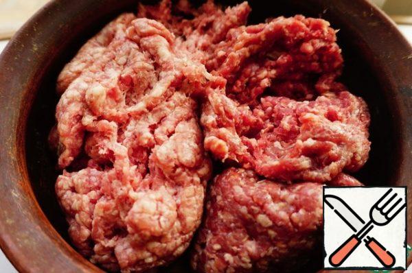 Preparing minced meat. Twist the pork and beef through a meat grinder.