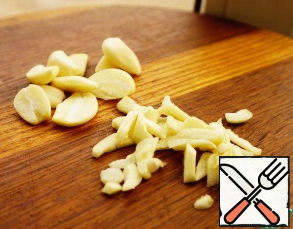 Peel 6 cloves of garlic and remove the middle from each (you can not remove the young garlic). Two cloves are cut into plates. They will go in a vegetable pillow-side dish.