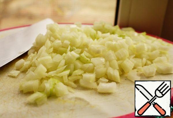 Start cooking a vegetable pillow. Clean and cut the onion into cubes.